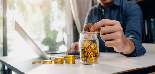businesswoman holding coins putting in glass with using smartphone and calculator to calculate concept saving money for finance accounting