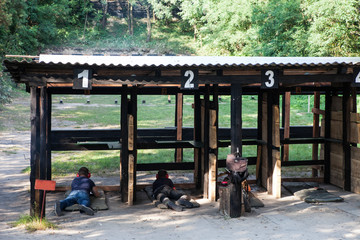 people shooting in a forest shooting range