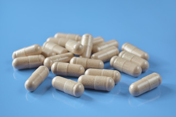 Heap pills-capsules on a light blue background, close-up. Shallow depth of field, selective focus. Healthcare concept.