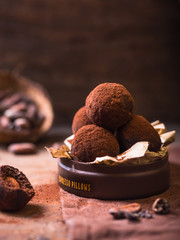 Homemade chocolate truffles  on wooden table closeup view. Tasty vegetarian candy or balls  with...