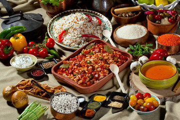 cooked and uncooked haricot beans, served with traditional cooked rice and Traditional red lentil soup. Table garnished with legumes, vegetables and seasonings. Rich cuisine, delicious food.