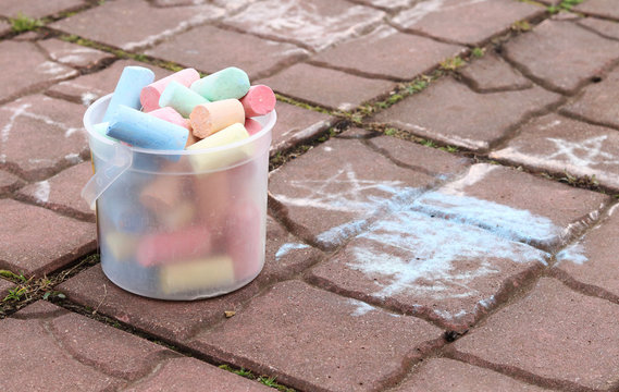 Large colored street chalk in a plastic bucket. 