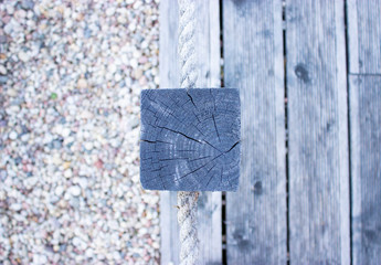 There is a terrace board and a lot of small stones near the river. Tree with a stone as a...