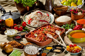 cooked and uncooked haricot beans, served with traditional cooked rice and Traditional red lentil soup. Table garnished with legumes, vegetables and seasonings. Rich cuisine, delicious food.