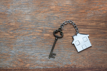 House key with home keyring on rusty wood background