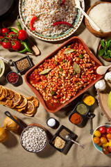 cooked and uncooked haricot beans, served with traditional cooked rice and Traditional red lentil soup. Table garnished with legumes, vegetables and seasonings. Rich cuisine, delicious food.