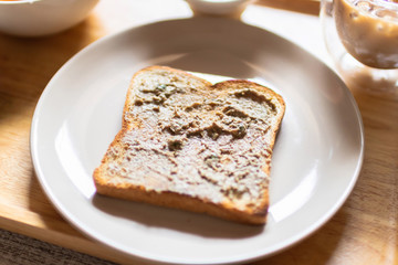 Chicken liver pate on bread with coffee on wooden tray.