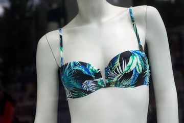 closeup of blue and green bikini on mannequin in fashion store showroom for women