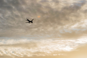 Single small airplane in the golden sky