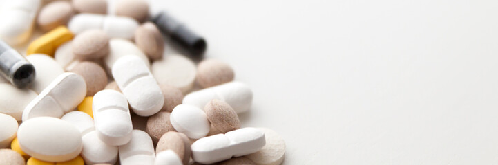 Fototapeta na wymiar Pile of pills isolated on white background. Copy space. Panorama.
