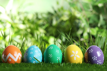 Colorful Easter eggs in green grass. Space for text