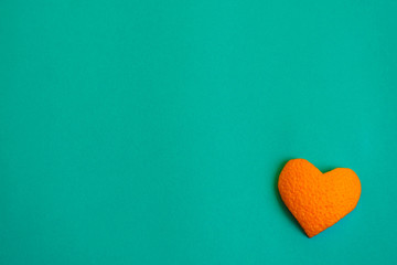 orange hearts carved out of their orange skin on a blue background . greeting card and background with a heart for the holiday