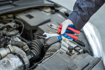 auto mechanic working with wrench key in car repairing, close-up