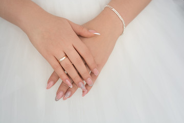 hands of the bride with a ring on white background
