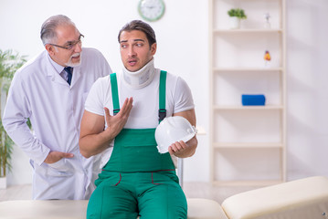 Fototapeta premium Young male contractor visiting old doctor