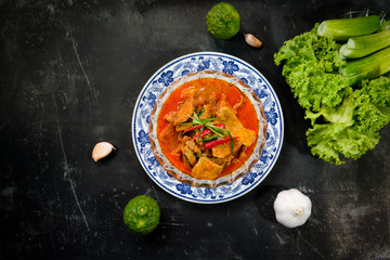 Top view of Thai food, spicy pork curry in coconut milk, traditional home cooking disk and restaurant on rustic background