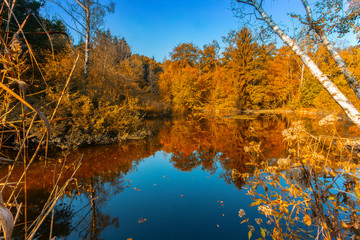 Kleiner See in Herbstlandschaft