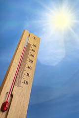 Wooden thermometer with red measuring liquid showing 40 degrees Celsius on a sunny day.
