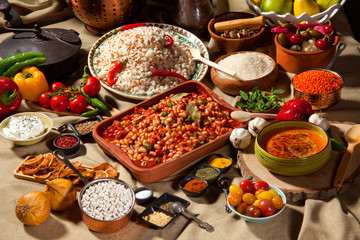 cooked and uncooked haricot beans, served with traditional cooked rice and Traditional red lentil soup. Table garnished with legumes, vegetables and seasonings. Rich cuisine, delicious food.