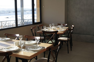 Dining table served with plates, glasses, forks and knives in cafe.