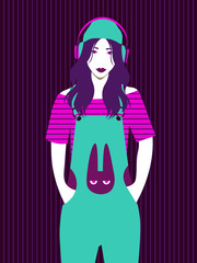 cute girl in overalls with bunny print listening to music in big headphones on striped background