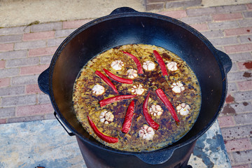 National Uzbek dish pilaf, pilaw, plov, rice with meat in big pan. Cooking process in a cauldron on...