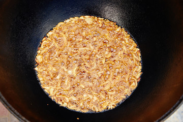 National Uzbek dish pilaf, pilaw, plov, rice with meat in big pan. Cooking process, open fire....