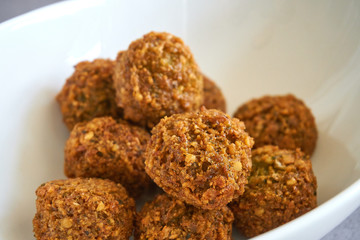 Close-up of fresh and crispy falafels balls inside a white bowl, authentic deep fried chickpea hot round falafels