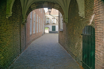 Medieval streets of historic city center of Delft, Netherlands. Travel or tourist abstract  cityscape. Empty streets usually full of tourists during Coronavirus quarantine lockdown.