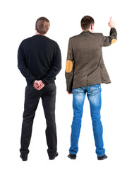 Back view of two man in sweater pointing.