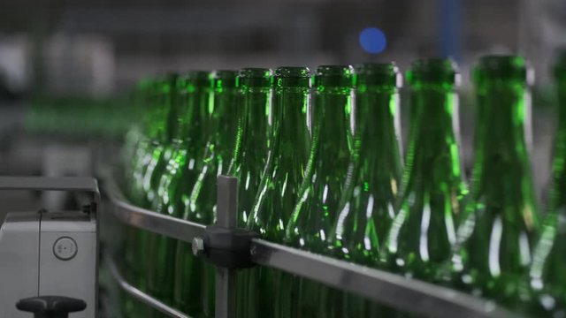 Wine bottles moving along a conveyor belt in a wine bottling factory. Manufacture of wine bottle. Glass recycling. Bottle manufacturing industrial factory. sparkle and still wines . prores HQ