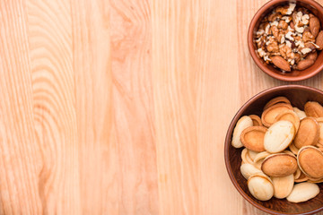 Homemade Russian nuts with condensed milk on a light pink background, wafer napkin. Cut nuts with condensed milk. Bitten goodies for coffee. Condensed Nuts. Flat lay