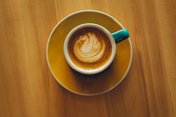 Top shot of a light blue cup filled with a cappuccino.
