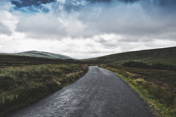 Wicklow Military Road in Ireland. Irish landscape. Empty road in the mountains. 
The Wicklow Mountains view in Ireland. Irish landscape. Green dark view.