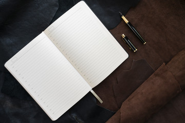 Flat lay - Notepad and pen on a leather background. workplace concept. copy space