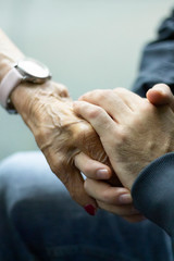 Grandson holding hands supporting her grandmother at the hospital