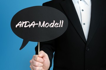 AIDA-Modell. Mann im Anzug hält Sprechblase in der Hand. Der Text AIDA-Modell steht im Schild. Blauer Hintergrund. Geschäftsmann für Business, Finanzen, Statistik