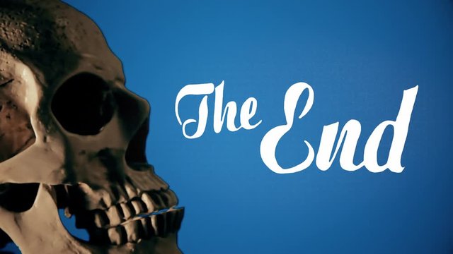A scary human skull on a rotating surface, on the left of the screen, with a text message appearing on the right, The End. Blue background.
