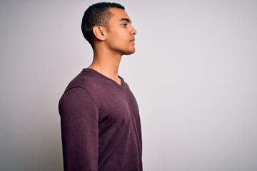 Young handsome african american man wearing casual sweater over white background looking to side,...