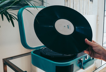 Young woman playing record on record player 