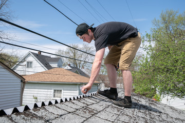 roofer is repairing a roof with corrugated asphalt