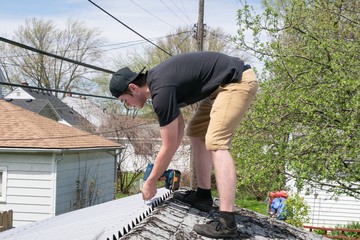 roofer is repairing a roof with corrugated asphalt