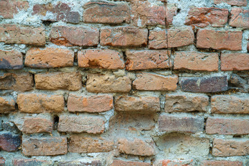 Grungy old red brick wall texture background with deterioration from age