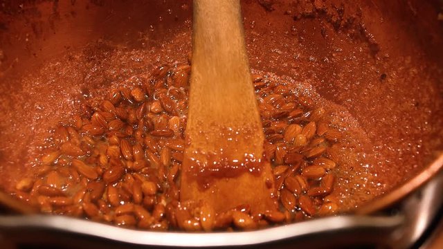 Scandinavian Christmas market - cooking almonds in caramel. Concept of Christmas tradition. Cold weather comfort food concept.