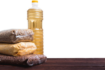 Raw porridge in a package and a bottle of sunflower oil. Stocks of cereals in the package.