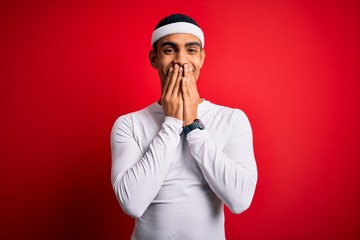 Young handsome african american sportsman wearing sportswear over red background laughing and...