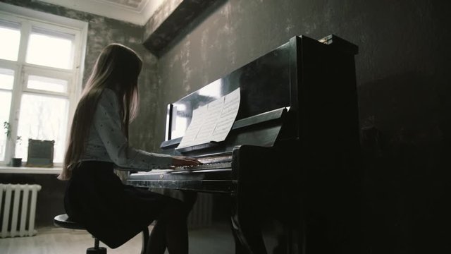 young girl plays the piano in the studio beautiful music