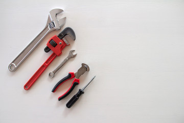 Male tools. Happy Father's Day inscription with screwdriver, Mechanic hand hold spanner tool, pliers on white background. Greetings and presents., copyspace, congratulation birthday for man, flatlay