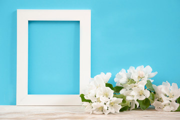 Creative layout with white flowers of an apple tree on a pastel blue background. Frame with copy space. Nature background. minimal idea.