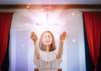 Christian Asian sitting in the Church catholic clasped hands worship praying to god with the bible begging for forgiveness and believe in goodness. Christian life crisis pray faith concept of religion